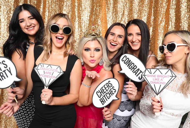 meerdere personen die met meegeleverde props op de foto gaan in ons photo booth