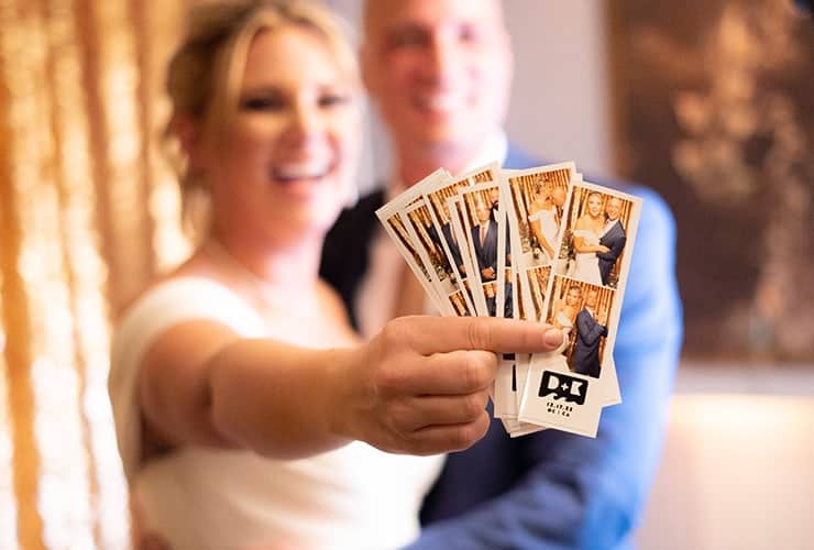vrouw laat uitgeprinte foto's van photobooth leiden zien